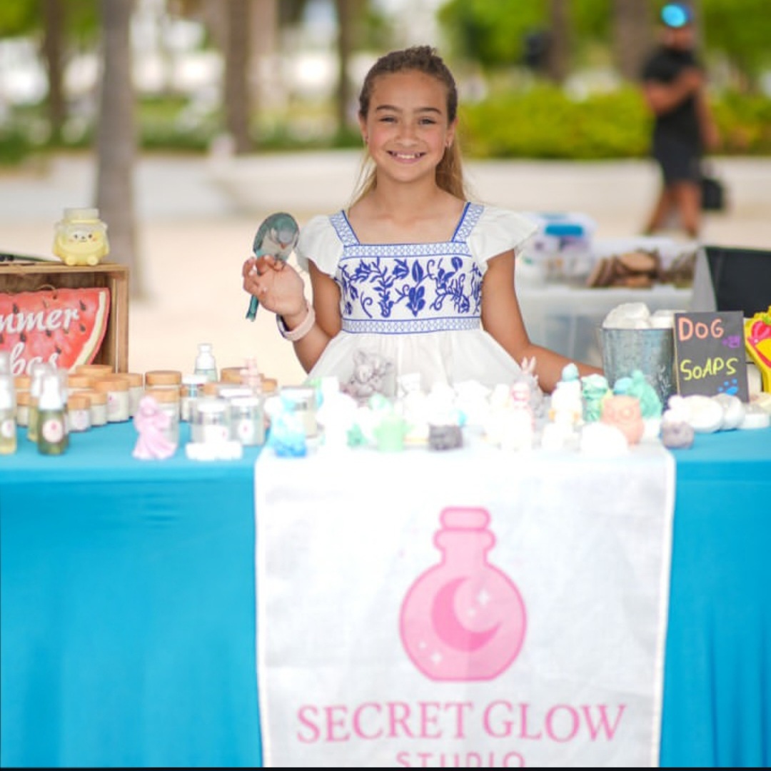 Adriana smiling with her pet parrot at the Secret Glow Studio booth